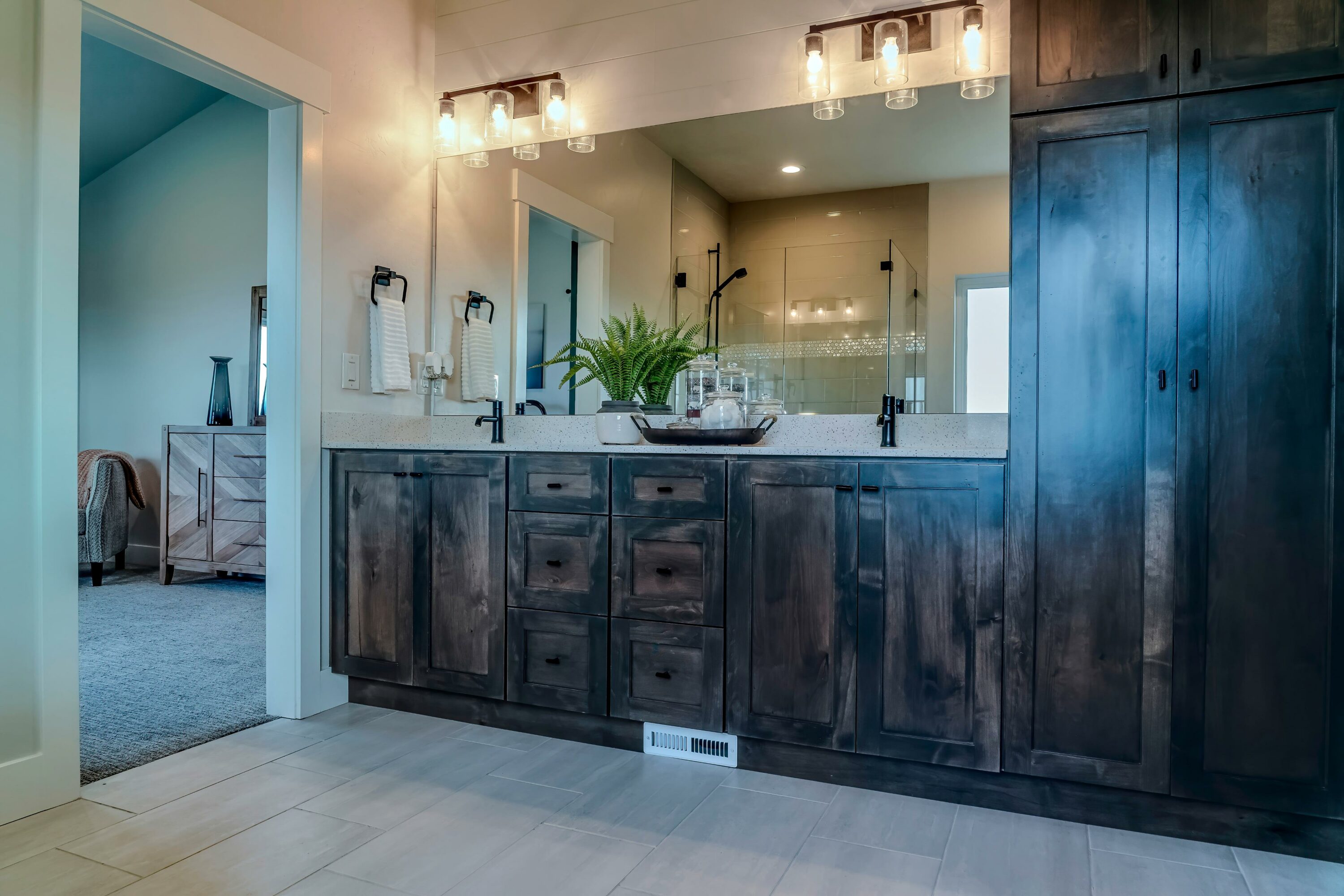 A bathroom with a dark wooden countertop, cabinets, and vanity