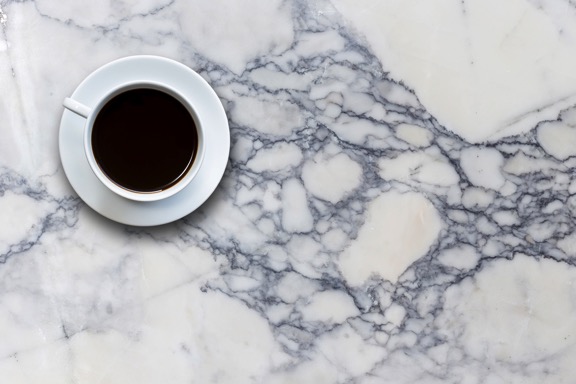 cup of coffee on blue vein and white counter top