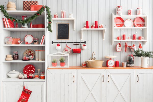 a rustic kitchen with white cabinets decorated with red and green Christmas decorations