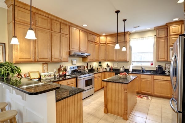 a well lit kitchen with brown cabinets